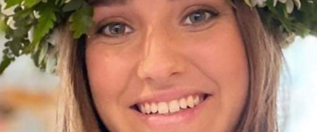 a woman wearing a hat and smiling at the camera